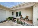 Inviting front porch featuring a seating area, decorative plants, and a textured exterior wall at 1615 Stonehaven Way, Tarpon Springs, FL 34689