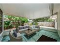 Covered patio with comfortable seating, a coffee table, and views of the lush backyard at 1615 Stonehaven Way, Tarpon Springs, FL 34689