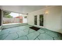 Enclosed patio featuring textured flooring, access to the backyard, and natural light at 1615 Stonehaven Way, Tarpon Springs, FL 34689
