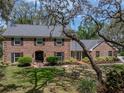 Charming brick home with black shutters, lush landscaping, and a front yard with a tree swing for outdoor enjoyment at 17515 Drake Ct, Lutz, FL 33559