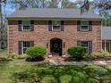The front of this brick home has manicured bushes and seasonal flowers around the front door entrance at 17515 Drake Ct, Lutz, FL 33559
