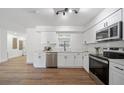 Bright modern kitchen with white cabinets, stainless steel appliances, and quartz countertops at 17815 Cranbrook Dr, Lutz, FL 33549
