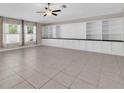 Expansive living room features tile floors, built in shelving and cabinets, and two windows at 1873 Colding Dr, Ruskin, FL 33570