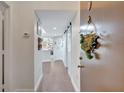 Bright hallway with wood floors leading to an open living space and a door decorated with greenery at 2411 W Horatio St # 526, Tampa, FL 33609