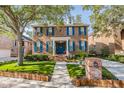 Beautiful two-story brick home with blue shutters, green lawn, and mature trees at 2704 Chambray Ln, Tampa, FL 33611