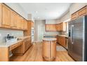 Bright kitchen with wood cabinets, stainless steel appliances, island with stove and ample counterspace at 2704 Chambray Ln, Tampa, FL 33611