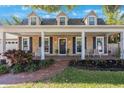 Inviting brick home with black shutters, a covered porch, and a brick walkway at 2718 W Leila Ave, Tampa, FL 33611