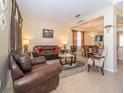 The living room features tile floors and a leather sofa set perfect for entertaining guests at 30526 Annadale Dr, Wesley Chapel, FL 33545