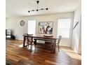 Dining room with a large table, wood floors, and bright windows at 32699 Dashel Palm Ln, Wesley Chapel, FL 33543