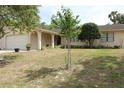 Welcoming home with a well-manicured lawn, complemented by mature trees, and brick paved walkway at 4363 Elwood Rd, Spring Hill, FL 34609