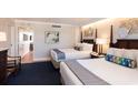 Bright hotel suite bedroom with two beds and a view to the sitting and dining area at 5500 Gulf Blvd # 2249, St Pete Beach, FL 33706