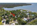 An aerial view shows the home nestled among lush greenery with a waterfront view, marked by a red arrow at 7417 Seagull Way, Tampa, FL 33635