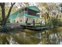 Waterfront home featuring a charming screened porch, dock, and a lush, picturesque landscape at 7417 Seagull Way, Tampa, FL 33635