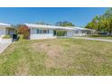 Well maintained single-story home with lush green lawn and white exterior and blue shutters at 9024 140Th Way, Seminole, FL 33776