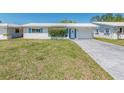 Single-story home featuring a white exterior, complemented by a well-kept lawn and mature landscaping at 9024 140Th Way, Seminole, FL 33776