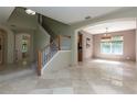 Open-concept living space with tile flooring, staircase, and natural light at 11102 Avery Oaks Dr, Tampa, FL 33625