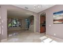 Open-concept living room showcasing tile floors, an arched entryway, and large windows letting in natural light at 11102 Avery Oaks Dr, Tampa, FL 33625