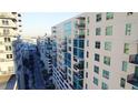 Exterior view of condo building with many balconies, neutral paint, and a clear blue sky at 1120 E Kennedy Blvd # 1208, Tampa, FL 33602