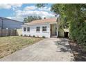 View of single story house featuring a well-kept lawn, white brick exterior, and concrete driveway at 1125 19Th N Ave, St Petersburg, FL 33704