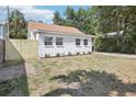Exterior angle of home showing the lawn, white brick, driveway, fence, and minimal landscaping at 1125 19Th N Ave, St Petersburg, FL 33704