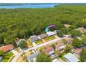 An aerial view of the property, nestled among lush greenery and trees with lake in background at 1144 Lanyard St, Palm Harbor, FL 34685