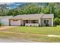 Welcoming single-story home with a well-maintained lawn, attached garage, and charming front porch at 1144 Lanyard St, Palm Harbor, FL 34685
