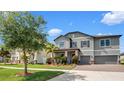 Charming two-story home featuring a brick driveway, two-car garage, and lush landscaping at 11720 Navajo Sandstone St, Riverview, FL 33579