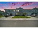Exterior view of townhomes at twilight, featuring a well manicured lawn at 12264 Grizzly Ln, New Port Richey, FL 34654