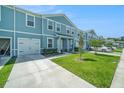 A well-maintained townhome exterior with a manicured lawn and a private driveway at 12264 Grizzly Ln, New Port Richey, FL 34654