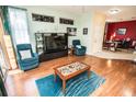 Comfortable living room with hardwood floors, blue furniture, and ample natural light at 1257 Lyndhurst Greens Dr, Sun City Center, FL 33573