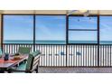 Relax on the screened-in balcony with dining space, offering stunning views of the beach and ocean at 13720 Gulf Blvd # 305, Madeira Beach, FL 33708