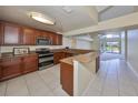 Open kitchen featuring granite countertops, wood cabinetry, and stainless steel appliances overlooking the pool at 1604 Storington Ave, Brandon, FL 33511