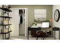 Well-lit home office with sleek black desk, open shelving, and closet for storage at 17572 Happytrails St, Land O Lakes, FL 34638