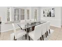 Elegant dining room with a glass table, seating for six, and a window seat for added charm at 215 Oceania Ct, Apollo Beach, FL 33572