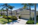Inviting single-story home featuring a two-car garage, landscaped yard, and gated front courtyard at 2246 Sifield Greens Way # 36, Sun City Center, FL 33573