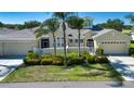 Charming single-story home boasting a well-kept lawn, lush landscaping, and a convenient two-car garage at 2246 Sifield Greens Way # 36, Sun City Center, FL 33573
