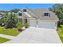 Beautiful home featuring lush landscaping, two car garage, and a welcoming facade at 2919 Northfield Dr, Tarpon Springs, FL 34688