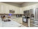 Well-lit kitchen with white cabinetry, stainless steel appliances, and granite countertops, offering a functional cooking space at 3647 Scarlet Tanager Dr, Palm Harbor, FL 34683