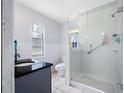 Modern bathroom featuring a glass-enclosed shower, granite countertop, and white tile flooring at 4124 Pine Dale Ct, Hernando Beach, FL 34607