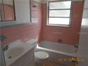 Retro bathroom featuring pink tiling, a bathtub, and a vanity sink offering functional space at 5318 7Th N Ave, St Petersburg, FL 33710
