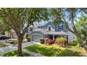 Two-story home with well-kept lawn, two-car garage, mature trees, and colorful landscaping at 6607 Gates Pointe Way, Riverview, FL 33578
