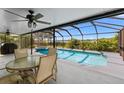 Screened-in pool area with ample seating, a ceiling fan, and a view of the lake at 6607 Gates Pointe Way, Riverview, FL 33578