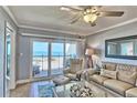 Light and airy living room with a comfortable seating area and sliding glass doors to a balcony with ocean views at 7480 Bayshore Dr # 402, Treasure Island, FL 33706