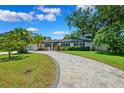 Charming single-story home featuring a lush front yard, paver driveway, and beautiful landscaping at 8231 31St N Ter, St Petersburg, FL 33710