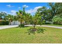 Well-manicured front lawn with a small fruit tree near a single story home with a paver driveway at 8231 31St N Ter, St Petersburg, FL 33710