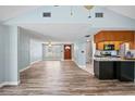 Open-concept living area with wood-look floors and easy access to kitchen and front entry at 8317 Needles Dr, Hudson, FL 34667