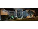 Charming single-story home with well-manicured landscaping and inviting front entrance at night at 8804 Poe Dr, Hudson, FL 34667