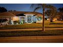 Charming single-story home with well-manicured landscaping and inviting front entrance at night at 8804 Poe Dr, Hudson, FL 34667