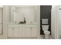 Bright bathroom with double vanity sink, granite countertops, and white cabinets at 9645 Runaway Breeze Dr, Land O Lakes, FL 34637