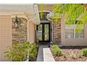 Inviting front entrance featuring stone accents, a decorative glass door, and manicured landscaping at 10141 Deercliff Dr, Tampa, FL 33647